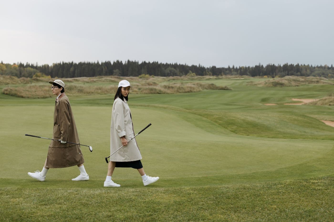 Two golfers heading up the fairway of a UK parkland course