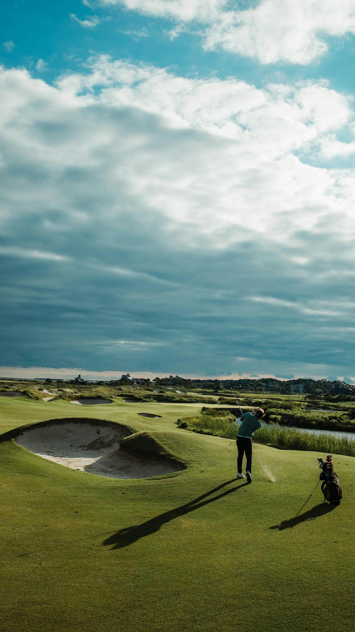 Golfer lining up a shot on a UK parkland course in morning light